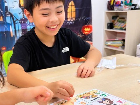 A child playing with illustrated cards spread across a table.