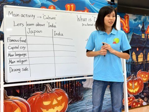 A teacher beside a whiteboard comparing Japan and India.